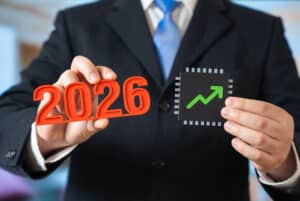 Businessman holding 2026 numbers and a growth symbol